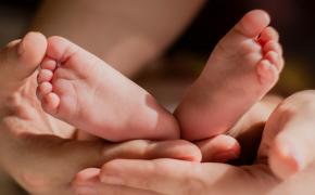 Käed hoidmas beebi jalgu